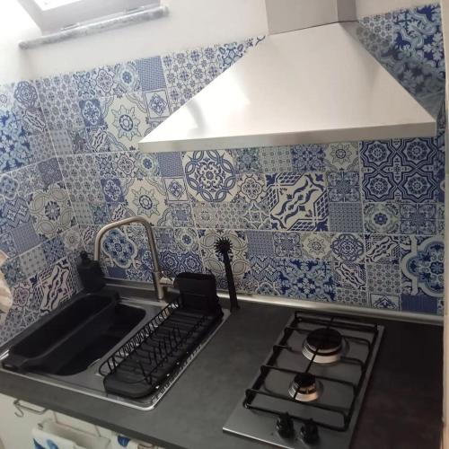 a kitchen with blue and white tiles on the wall at Domus Julia in Furore