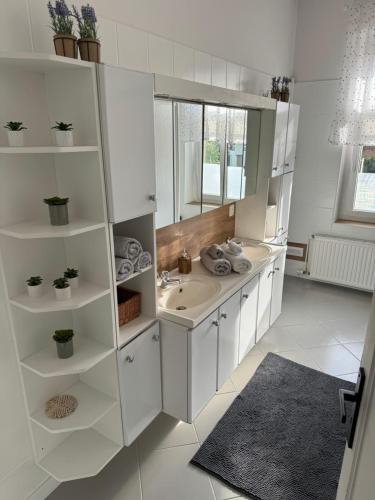 Baño blanco con lavabo y espejo en Apartament ALMAR Cieplice-Zdrój en Jelenia Góra