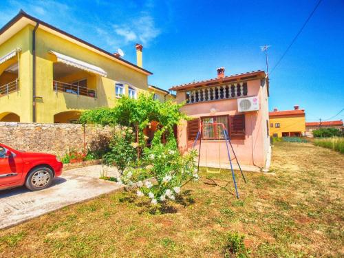 een huis met een rode auto ervoor geparkeerd bij Ferienwohnung für 5 Personen ca 75 qm in Marčana, Istrien Südküste von Istrien in Marčana