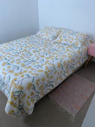 a bed with a floral comforter on top of it at Departamento para 6 personas amoblado in Los Andes