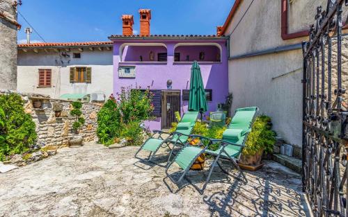 a group of chairs and an umbrella in front of a building at Ferienhaus für 5 Personen ca 70 qm in Rakalj, Istrien Bucht von Raša in Rakalj