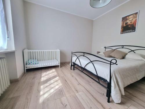 1 dormitorio con 1 cama y suelo de madera en Maison Martina 'Free Parking' en Aosta