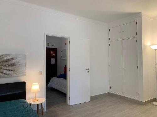 een witte slaapkamer met een bed en een kast bij Happydreams apartment in Albufeira in Albufeira