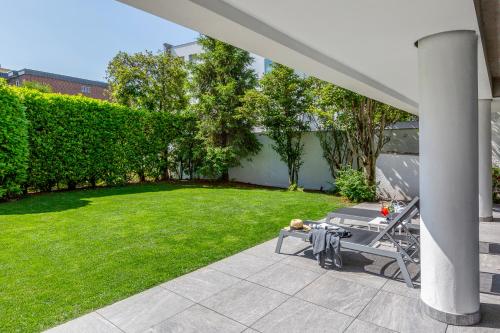 a patio with a table and a green yard at Sasso Boretto, Luxury Holiday Apartments in Ascona