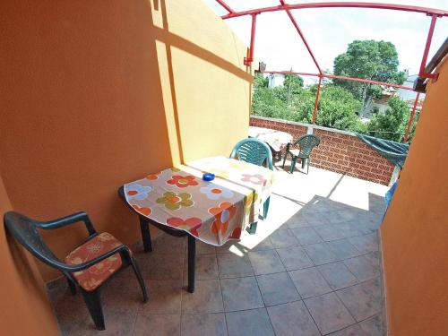 a patio with a table and chairs and a balcony at Ferienhaus für 2 Personen ca 16 qm in Medulin, Istrien Südküste von Istrien in Medulin