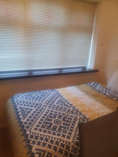 a bedroom with a window with a blanket on a bed at Tavern Court Shared Facilities in Manchester