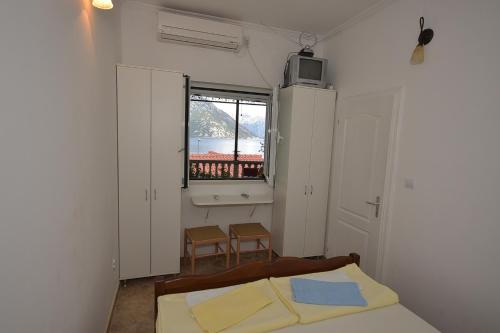 a bedroom with a bed and a window at Apartments Morinj in Donji Morinj