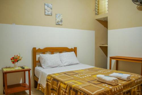 1 dormitorio con 1 cama con 2 toallas en Hospedaje Guadalupe Inn, en Máncora