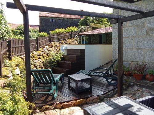 un patio con mesa y sillas en una terraza en Ninho do Corvo da Urgueira, en Urgueira