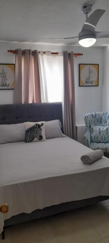 ein großes Bett in einem Schlafzimmer mit Fenster in der Unterkunft Residencial Palmas De Gurabo in Santiago de los Caballeros