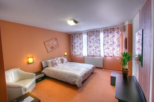um quarto com uma cama, um sofá e uma cadeira em Family Hotel Mania em Stara Zagora