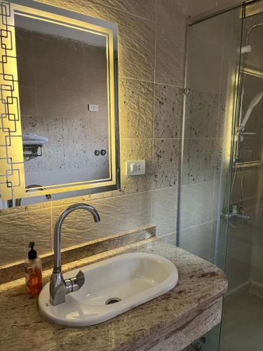 a bathroom with a sink and a glass shower at Monte cairo Pool View in Cairo