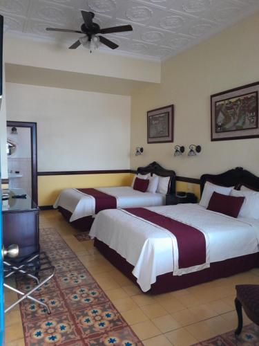a hotel room with two beds and a ceiling fan at Hotel Santo Tomas / Historical Property in San José