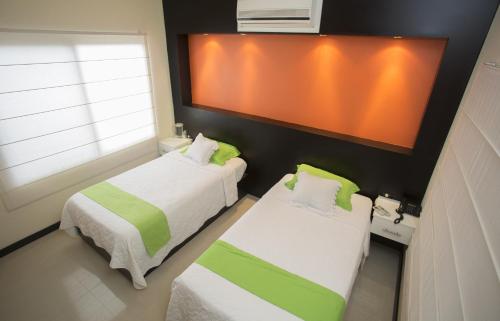 a small room with two beds and a window at Hotel San Vicente Galapagos in Puerto Villamil