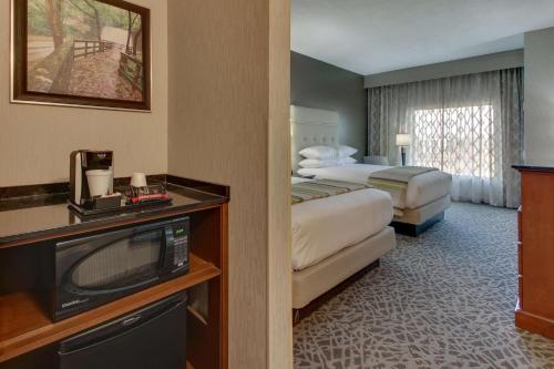 a hotel room with two beds and a television at Drury Plaza Hotel Savannah Pooler in Savannah