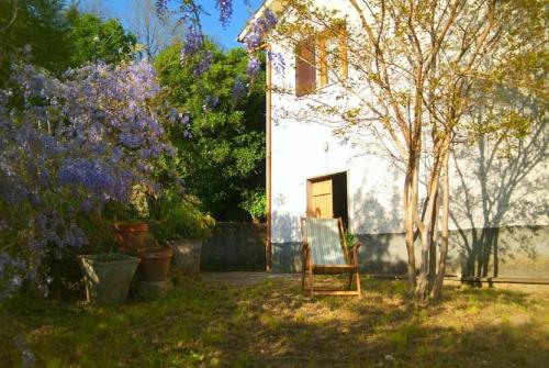 una silla sentada en un patio junto a un edificio en Ferienhaus in Caregli mit Garten und Grill, en Borzonasca