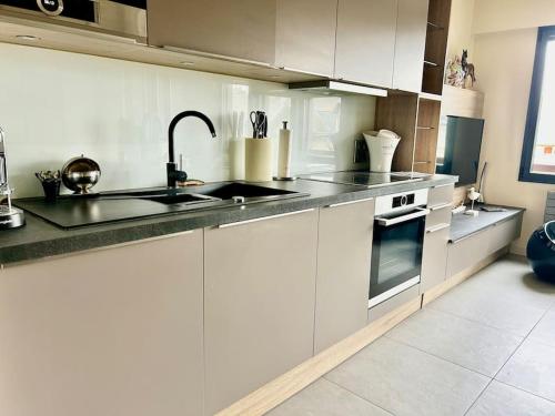 une cuisine blanche avec un évier et une cuisinière dans l'établissement Le coeur de Deauville, à Deauville