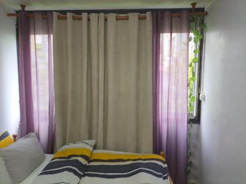 ボビニーにあるParisian private room near city center by metro 5のカーテンと窓が備わるドミトリールームのベッド1台分です。