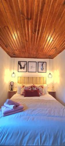 a bedroom with a large bed with a wooden ceiling at Carlana House in Paredes de Coura