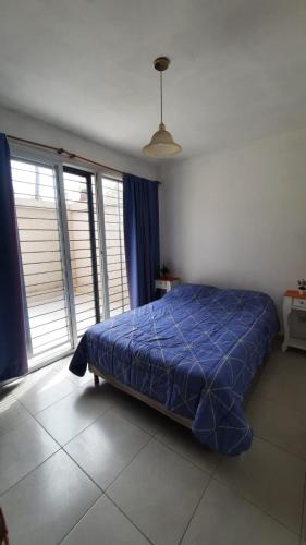 a bedroom with a bed with a blue comforter at Departamento Citrino in Godoy Cruz