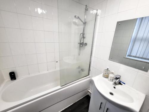 a white bathroom with a shower and a sink at Stay Sleep Rest - Grove Haven in Hull