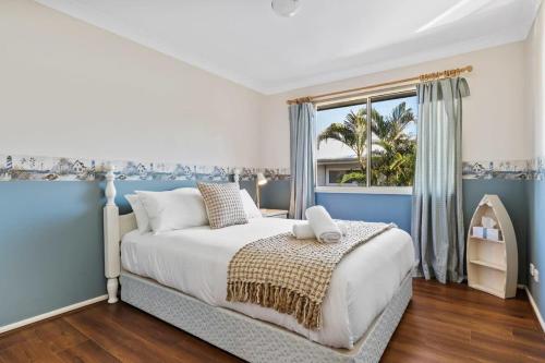a bedroom with a large bed and a window at Swim Spa- 5mins to beach and golf - Pet Friendly in Shelly Beach