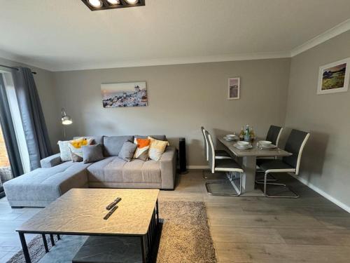 a living room with a couch and a table at 2 bedroom House with Parking & Garden in Sunbury Common