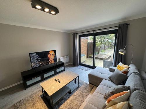 a living room with a couch and a coffee table at 2 bedroom House with Parking & Garden in Sunbury Common