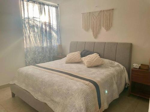 a bed with two pillows on it in a bedroom at Charming and Cozy Condo San Blas in Puerto Vallarta