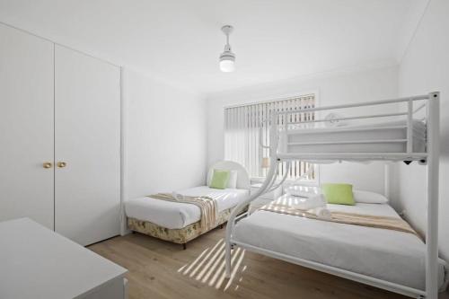 two bunk beds in a room with white walls at Lakeview Tranquility Budgewoi in Budgewoi