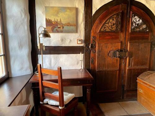 a room with a desk and a wooden door at Ferienhaus Waffenkammer für 7 Personen in Leppersdorf