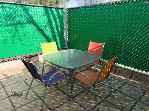a green table and chairs with a green fence at Casa María Sabina in San Juan del Río
