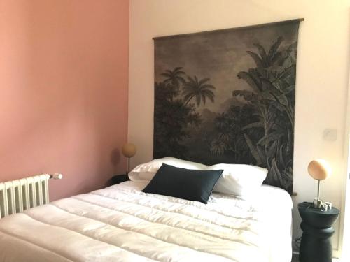 une chambre avec un lit avec un tableau sur le mur dans l'établissement LE PRESBYTERE - HyperCentre - Rez de Chaussée - Thermes, à Vichy