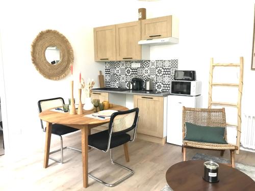 une cuisine et une salle à manger avec une table et des chaises dans l'établissement LE PRESBYTERE - HyperCentre - Rez de Chaussée - Thermes, à Vichy