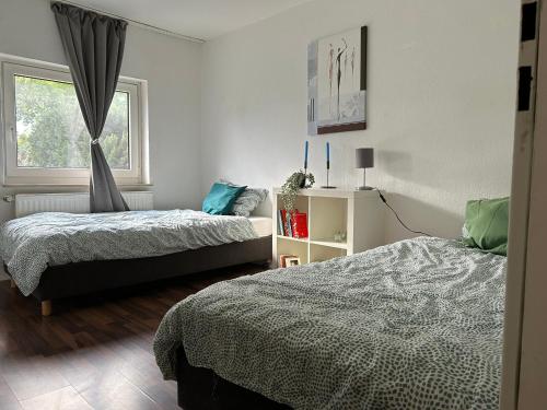 1 dormitorio con 2 camas y ventana en Wunderschönes Haus mit Garten für 10 Personen en Hannover
