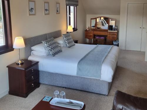 a bedroom with a large bed and a desk at Loch View, Lairg in Lairg
