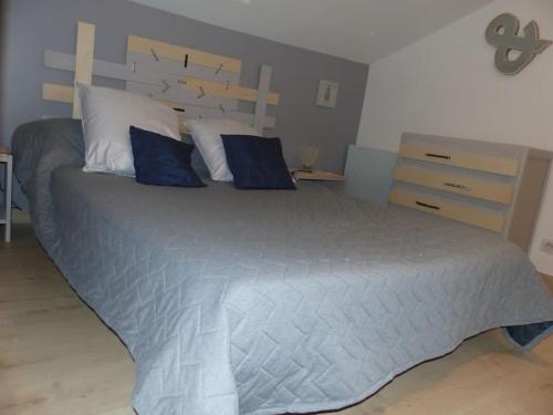 une chambre avec un grand lit avec des oreillers bleus dans l'établissement Duplex climatisé proche palais des papes, à Avignon