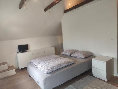 a white bedroom with a bed and a tv at Billig overnatning tæt på badestrand og jesperhus in Roslev