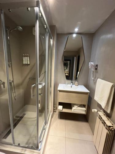 uma casa de banho com um chuveiro e um lavatório. em Hotel Martín Gusinde em Puerto Natales