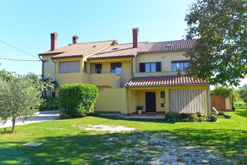 duży żółty dom z zielonym dziedzińcem w obiekcie Ferienhaus für 7 Personen ca 120 qm in Grandici, Istrien Bucht von Raša w mieście Grandići
