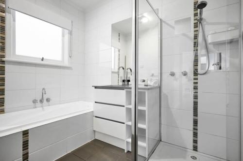 a white bathroom with a sink and a shower at Modern Beach House - Dromana in Mornington