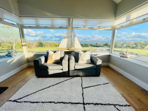 a living room with a couch in front of a large window at Conree Lodge in Castlemaine