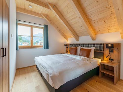 a bedroom with a large bed and a window at Riesner Alpenlodge in Donnersbachwald