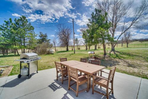 a table and chairs on a patio with a grill at 2 Mi to Dtwn Castle Rock Home with Furnished Patio in Castle Rock