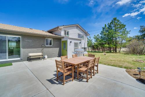 a patio with a wooden table and chairs at 2 Mi to Dtwn Castle Rock Home with Furnished Patio in Castle Rock
