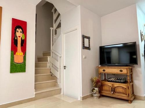 a hallway with a flat screen tv and a staircase at DÚPLEX HUERTA DE ENMEDIO in Conil de la Frontera