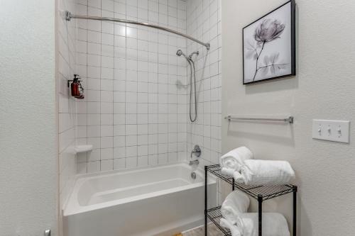 een badkamer met een bad, een douche en handdoeken bij Spectacular Condo facing Riverwalk w Free Parking Pet Friendly Centrally Located on Riverwalk in San Antonio