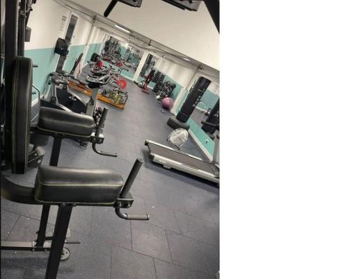 un gimnasio con sillas y máquinas en una habitación en Paradise - Away - From - Home, en Bracknell
