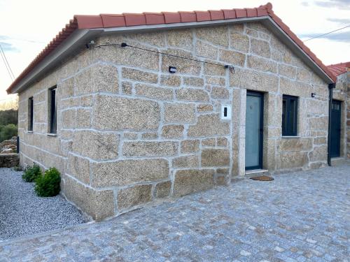 ein Steingebäude mit einer Seitentür in der Unterkunft Casa da Ti Mília in Trancoso