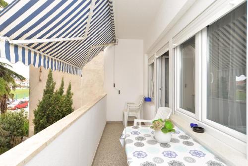 un balcón con una mesa y una sombrilla azul y blanca en Ferienwohnung für 4 Personen ca 40 qm in Fažana, Istrien Istrische Riviera - b43347, en Fažana